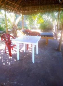 een witte tafel en twee stoelen onder een paviljoen bij Moringa Garden Cottage, mombasa, north coast, kikambala in Mtwapa