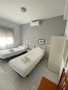 une chambre à l'hôpital avec deux lits et une fenêtre dans l'établissement Hostal Carlos III, à Aldea Quintana