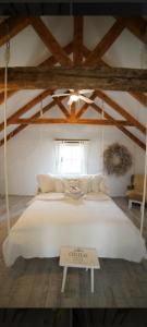 a large white bed in a room with wooden ceilings at Vinný Tunel in Pouzdřany