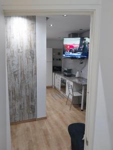 ein Wohnzimmer mit einem Schreibtisch und einem TV an der Wand in der Unterkunft Céntrico apartamento con patio in Madrid