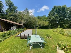 a table and chairs in the grass in a yard at Domaine Pierrot in Laujuzan