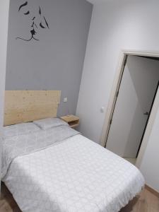 a bedroom with a white bed with birds on the wall at Céntrico apartamento con patio in Madrid