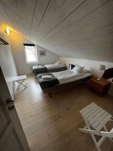 an attic room with two beds and a chair at Visby City Apartments S:t Hansgatan in Visby