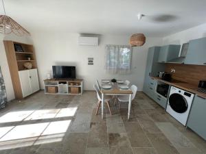 een keuken met een tafel en stoelen in een kamer bij La Bastide d’Elma - CLIM - WIFI in Sarrians