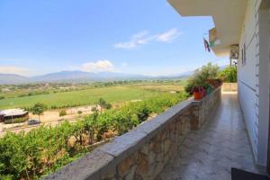 a balcony with a stone wall and a view of a field at Koci Apartments in Sarandë