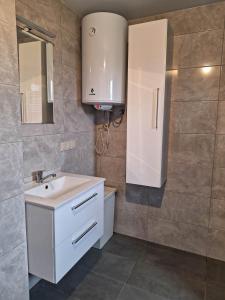 a bathroom with a white sink and a mirror at Domek letniskowy w Trzęsaczu in Trzęsacz