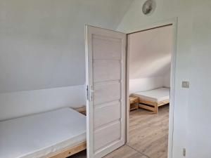 トシェンサチにあるDomek letniskowy w Trzęsaczuのクローゼット(ベッド1台、鏡付)が備わる客室です。