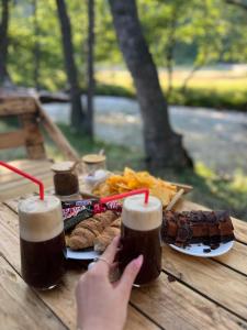 una mesa con un plato de comida y dos vasos de cerveza en Lightwood cabins, en Kʼareli