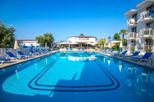 a large swimming pool with chairs and a hotel at Bahar Hotels in Fethiye