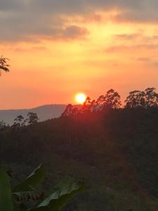 una puesta de sol con la puesta de sol en el horizonte en Recanto Vista Mantiqueira en Guararema