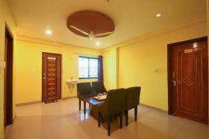 a dining room with yellow walls and a table and chairs at Super OYO Ssj Residency in Khandagiri