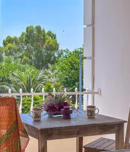 ein Holztisch mit Blumen darauf auf einer Veranda in der Unterkunft Abelia Otel in Canakkale