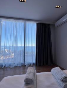 a bedroom with two beds and a large window at Le Rêve Boutique Hotel in Dhërmi