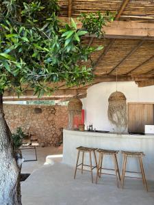 a restaurant with a bar with two stools and a tree at Le Rêve Boutique Hotel in Dhërmi