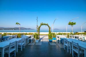 een rij tafels en stoelen met het strand op de achtergrond bij Bahar Hotels in Fethiye