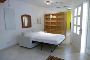 a bedroom with a white bed and a book shelf at Traumhafte Maisonnette mit Kamin in Vienna