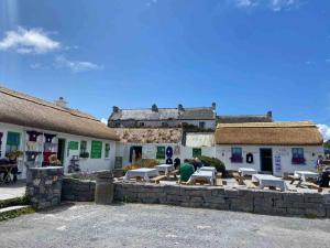 un gruppo di edifici con tavoli e sedie in un cortile di Irish Isle Oasis: Spacious 5-Bedroom Retreat a Bungowla