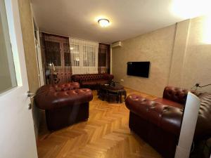 ein Wohnzimmer mit Ledermöbeln und einem Flachbild-TV in der Unterkunft GBS Usce Apartments in Belgrad