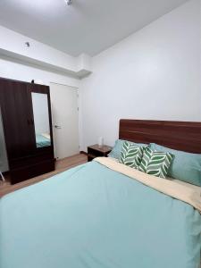 Affordable 2BR with Terrace Shan Place Infina Tower-QC في مانيلا: غرفة نوم بسرير كبير ومرآة