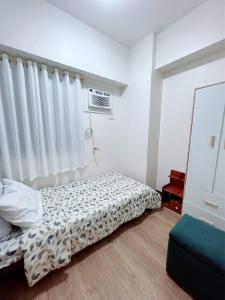 Un pat sau paturi într-o cameră la Affordable 2BR with Terrace Shan Place Infina Tower-QC