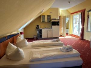 a bedroom with two beds with towels on them at Hotel Ostseeblick in Ostseebad Karlshagen