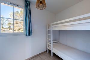 a bedroom with bunk beds and a window at La Cabre d'Or - Duplex avec piscine partagée in Cabriès