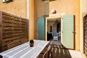 a patio with a table and a fence and a door at La Cabre d'Or - Duplex avec piscine partagée in Cabriès