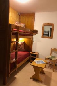 a room with a bunk bed and a table at Les aiguilles d arves n 29 in Albiez-Montrond