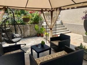un patio con sillas, un columpio y una sombrilla en Apartment "JONA ", en Niš