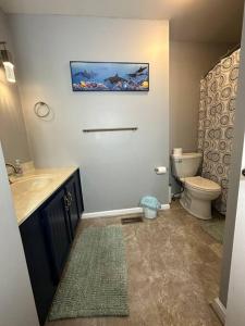 La salle de bains est pourvue de toilettes et d'un lavabo. dans l'établissement Serenity - Waterfront 3 Bed, 2 Bath, Water Toys, EV Charger, à Bracey