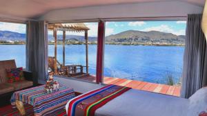 Schlafzimmer mit Blick auf einen Wasserkörper in der Unterkunft Titicaca Sariri Lodge in Puno