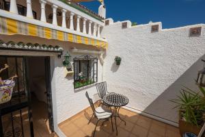 een terras met een tafel en stoelen naast een gebouw bij Mandarinos 16 Urb SJ de Capistrano in El Molino
