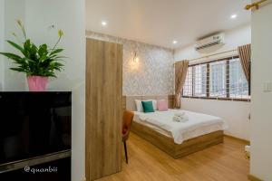 a bedroom with a bed and a flat screen tv at Kansas Hotel & Apartment - Notre Dame in Ho Chi Minh City