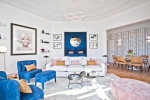 a living room with a white couch and blue chairs at JOIVY Luxury 3 bed, 3 bath flat with terrace, near Estrela Garden in Lisbon