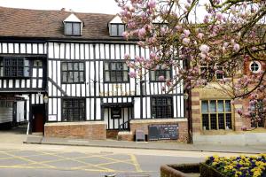a building with a flowering tree in front of it at White Hart Hotel in Saint Albans