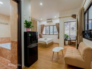 a bathroom with a tub and a living room with a couch at Kansas Hotel & Apartment - Notre Dame in Ho Chi Minh City