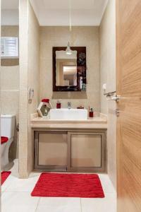 baño con lavabo blanco y alfombra roja en New luxury apartment in Marrakech, en Marrakech