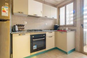 cocina con armarios blancos y fogones en New luxury apartment in Marrakech, en Marrakech