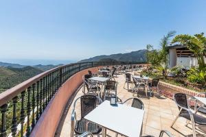 Hotel Wellness Marbella Hills في أُوخين: صف من الطاولات والكراسي على الشرفة