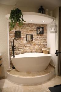 a bath tub in a bathroom with a stone wall at Chez Julien & Mathieu in Valras-Plage +21 photos