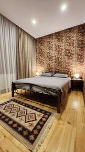 a bedroom with a large bed and a rug at Velio Guest House in Velistsʼikhe