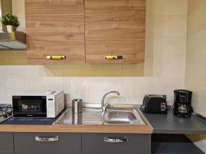 a kitchen with a sink and a microwave at Griseo - Sicily Holiday House in Misterbianco +16 photos