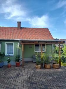 una casa verde con techo rojo y macetas en Töpferblick, en Olbersdorf