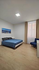 a bedroom with a blue bed and a blue chair at B&B IMMARE in Brindisi