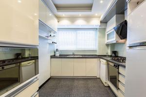 a large kitchen with white cabinets and a window at Comfy Flat near Trendy Attractions in Sisli in Istanbul