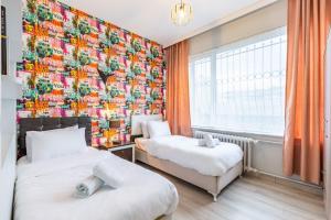 two beds in a room with a colorful wall at Comfy Flat near Trendy Attractions in Sisli in Istanbul