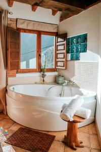 uma banheira na casa de banho com uma janela em Carbayu Senda del Oso em Proaza