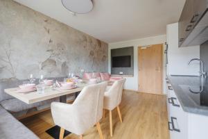 cocina y comedor con mesa y sillas en hin&weg das Aparthotel, en Ried im Zillertal