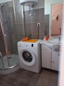 ein Badezimmer mit einer Waschmaschine und einem Waschbecken in der Unterkunft Dani in Zadar