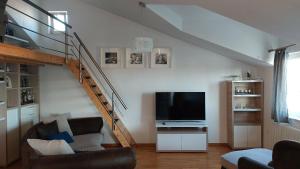 a living room with a staircase and a television at Mislav Apartment in Trogir